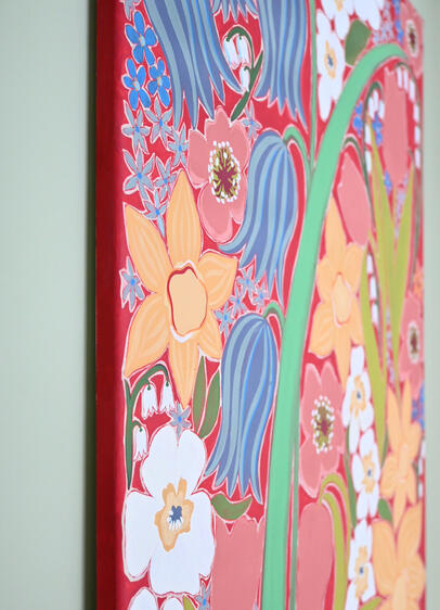 Close up of a large floral painting with a red background.